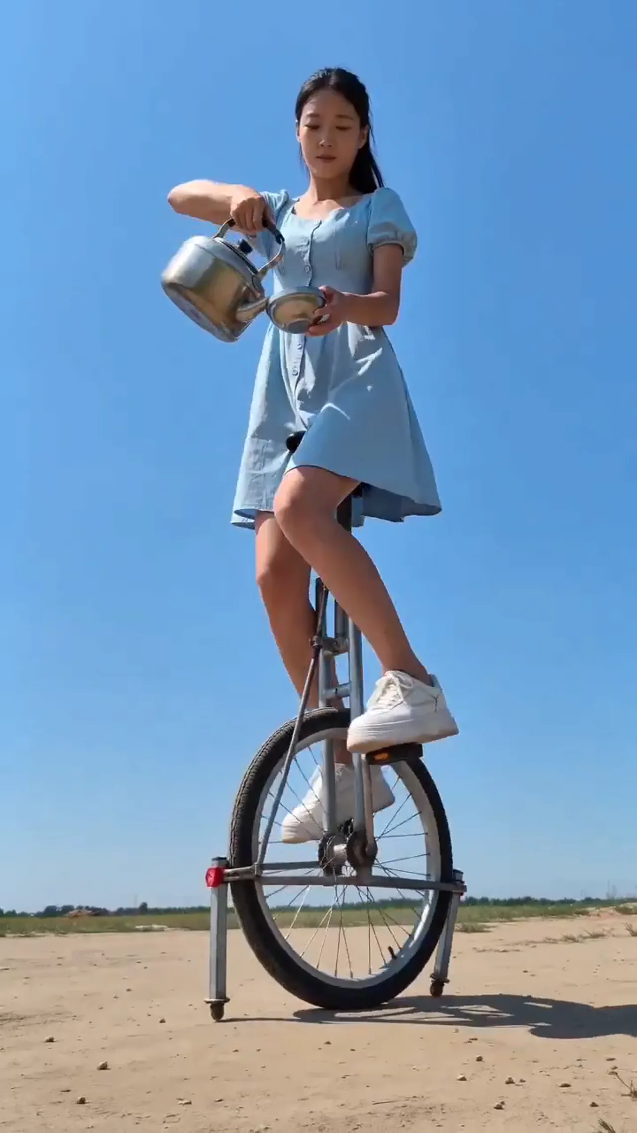 Woman Drinking Tea on a Unicycle